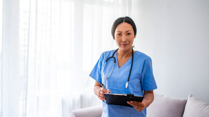  Woman healthcare worker with clipboard. Portrait of confident young Asian female doctor. Doctor...