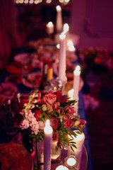 Burning candles on a festive table. A festive table with candles