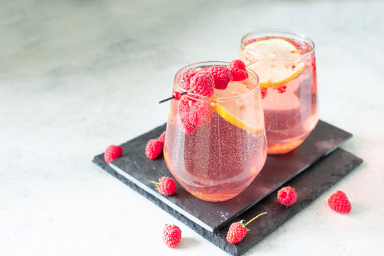 Sparkling pink raspberry lemonade on grey background