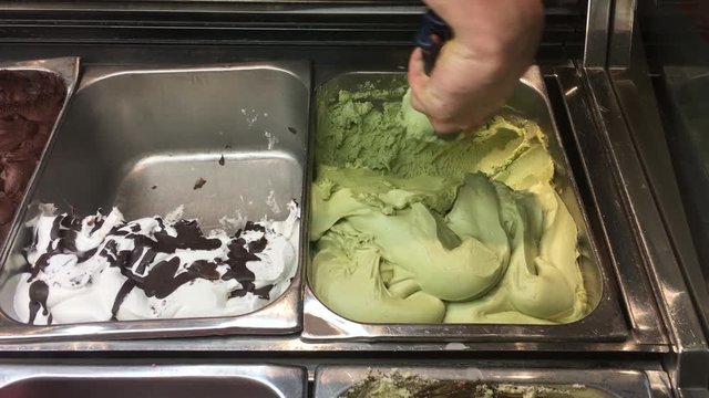 Scooping pistacchio ice cream from bin 4k