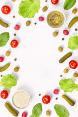 Salad ingredients layout on white desk. Food pattern with cherry tomatoes, cucumbers, greens, pepper and spices
