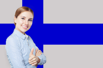 Finland. Young happy cute girl with thumb up against the Finnish flag background. Student or...