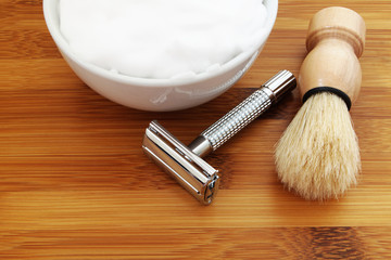 Shaving accessories on wooden background. Razor, brush, towel and foam