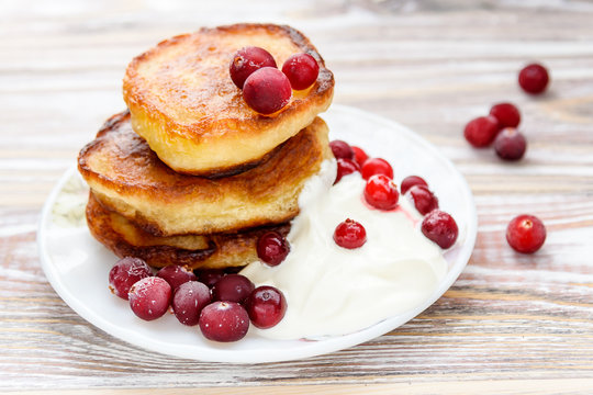 Pancakes with berries and sour cream on a plate. Summer cottage of Russian delicacies