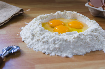 Eggs and flour on wooden table close up