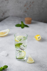 mint lemonade on grey background with lemon zest and mint leaves