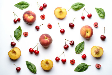 Culinary background, food blog, recipe concept. Layout of ripe sweet cherries and peaches on white. Seasonal dessert. Delicious vegetarian meals and diet concept
