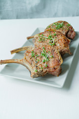 Grilled steaks from pork ribs with spices and herbs. Bone steak. Side view. Dark wooden background. © Юлия Ромашко