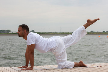 Fototapeta na wymiar Young man doing yoga in morning park.man relax in nature