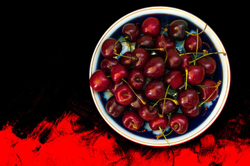 Ripe sweet cherry in a plate on a picturesque surface