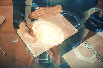 Cryptocurrency hologram over woman's hands writing background. Concept of blockchain. Multi exposure