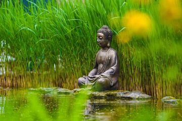 Fototapeta na wymiar Buddha statue on the shore of the lake