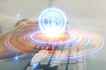 Crypto currency theme hologram with businessman working on computer on background. Concept of blockchain. Multi exposure.