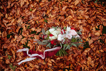 autumnal bridal bouquet. bride holding wedding bouquet of autumn leaves, flowers, berries and pomegranate. closeup