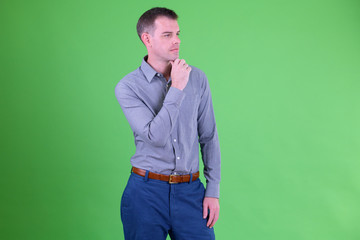 Portrait of businessman thinking against green background