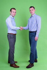 Full body shot of two businessmen shaking hands together