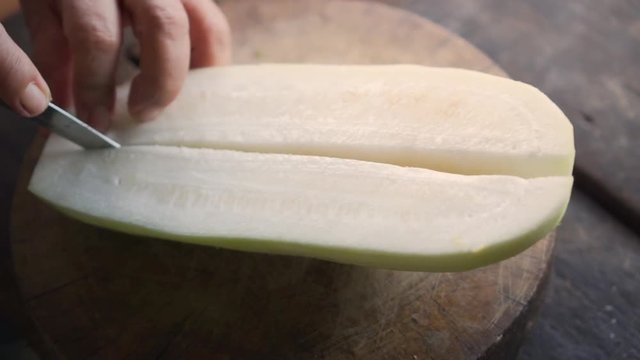 Winter melon get split in half with knife. Ingredient for cooking soup.