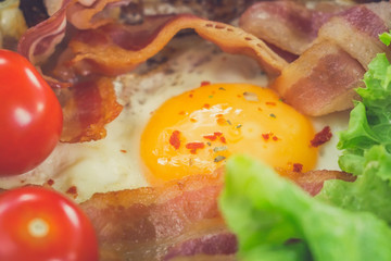 Sunny Side Up Eggs with crispy fried bacon, arugula and tomatoes