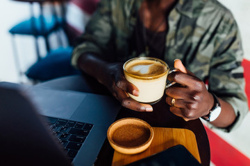 Close up photo of american male holding cup of latte with heart.
