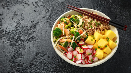 Asian style Vegan salad bowl with edamame, vegetable stir-fry mix, wholegrain rice, quinoa, mango chunks drizzled with mango, chilli dressing