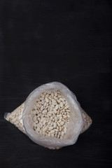 white beans in a plastic bag on a black background. concept. Trend. Plasicfree