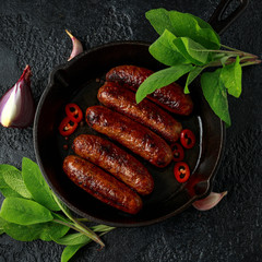 Butcher made sage and onion sausages baked in cast iron skillet, pan