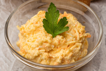 Bowl with grated cheese and garlic sauce on a light background. Close up