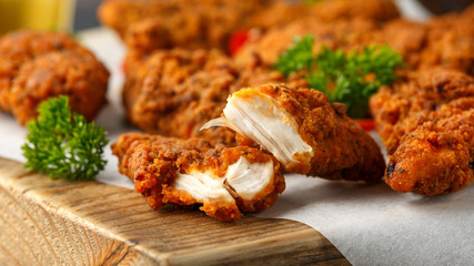Breaded chicken strips with beer, ketchup and mayonnaise on wooden board