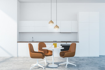White kitchen interior with table and brown chairs