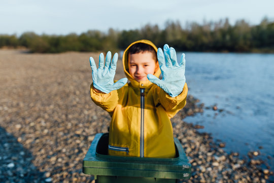 Children hands in blue gloves picking up  garbage and help pollution  ,volunteer concept near river.