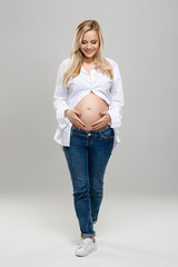 Young pregnant woman in studio. Beautiful stomach. Pregnancy, childbearding and new life concept.