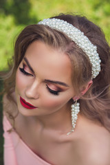 Beautiful woman with pearl jewelry and accessories Bridesmaid in peach dress