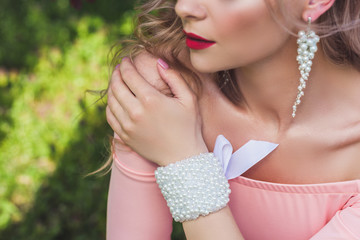 Beautiful woman with pearl jewelry and accessories Bridesmaid in peach dress
