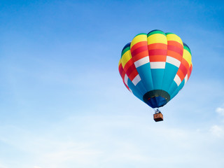 Hot air balloon in Flight with blue sky background with copyspace