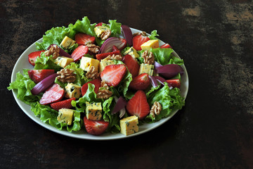 Keto salad with strawberries, blue onion and blue cheese. Healthy summer strawberry fitness salad.