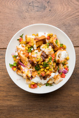 Bread chaat/chat is a yummy starter/appetizer from India, served in a bowl garnished with tomato, sev and coriander and masala. selective focus