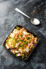 Bread chaat/chat is a yummy starter/appetizer from India, served in a bowl garnished with tomato, sev and coriander and masala. selective focus