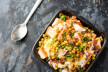 Bread chaat/chat is a yummy starter/appetizer from India, served in a bowl garnished with tomato, sev and coriander and masala. selective focus