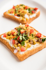 Bread ppadi chaat/chat is a yummy starter/appetizer from India, served in a plate garnished with tomato, sev and coriander and masala. selective focus