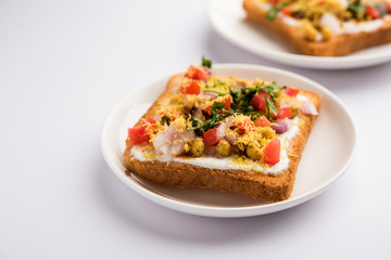 Bread ppadi chaat/chat is a yummy starter/appetizer from India, served in a plate garnished with tomato, sev and coriander and masala. selective focus