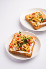 Bread ppadi chaat/chat is a yummy starter/appetizer from India, served in a plate garnished with tomato, sev and coriander and masala. selective focus