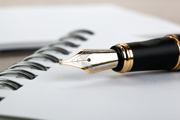 fountain pen on the notepad on a table