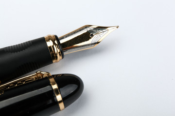 golden fountain pen on a white paper