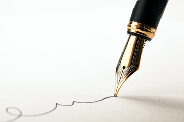 Fototapeta golden fountain pen leaves a signature on a white paper obraz