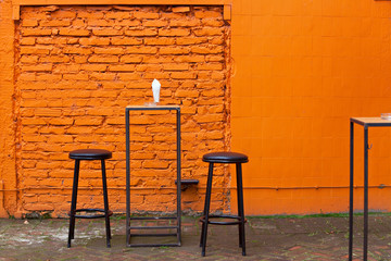 Orange brick wall half covered in orange tiles, outdoors