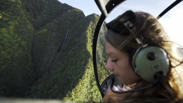 Slow Motion: Young Woman Looks at Hawaiian Waterfall from Helicopter, Kauai, Hawaii