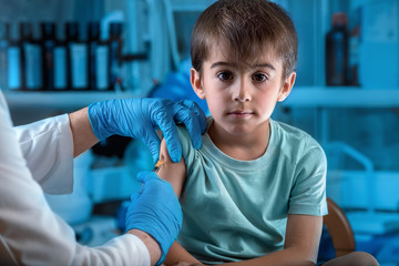 doctor injecting vaccine preventive to little boy in the hospital