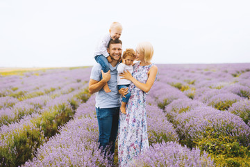 Lovely portrait of a young beautiful family outdoors in a lavender field. Family time. Perfect family.