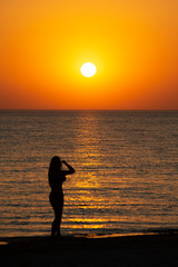 woman watching the sunset on the beach. the concept of a healthy lifestyle