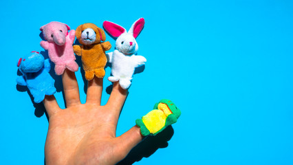 Puppet theater of doll  animals. Hand wearing finger puppets: elephant, frog, dog, rabbit,...